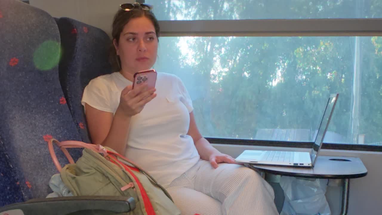 Woman Engaged with Her Smartphone While Traveling by Rail