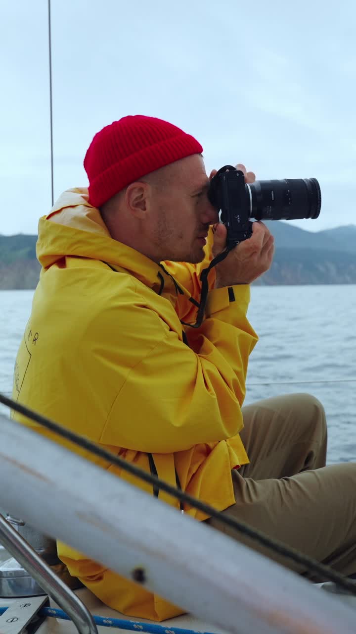 Man in Yellow Jacket Taking Photos from a Boat on the Sea