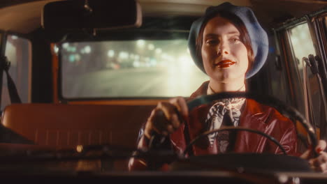 smiling retro-dressed woman driving vintage car in city at night