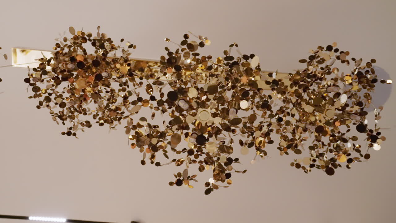 mirando hacia arriba en la elegante lámpara de techo dorada en un hotel de lujo