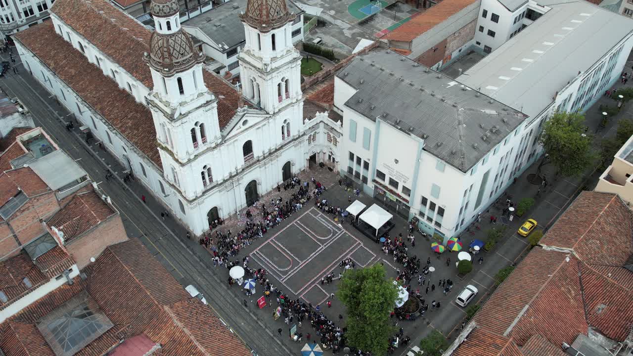 4K aerial footage of the Faroles procession in Cuenca, Ecuador. People walk with lanterns in front of Santo Domingo Church, celebrating a colorful and spiritual cultural tradition at night.