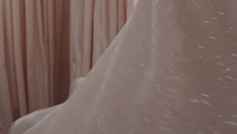 happy bride wearing shiny wedding dress spins around in room