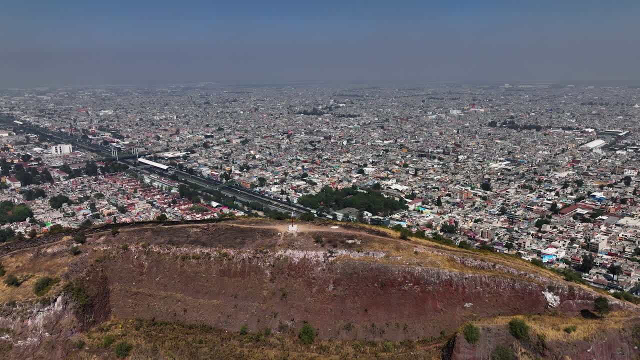 vista aérea sobre una montaña, con vistas a una cantidad interminable de zonas residenciales pobres de la ciudad de méxico