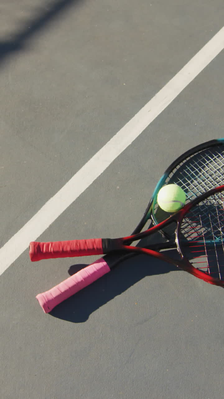 Video of tennis ball and rackets lying on tennis court