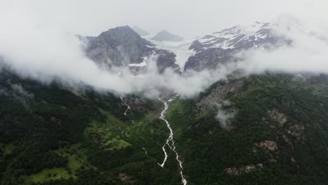 misty mountain valley with glacier and waterfalls