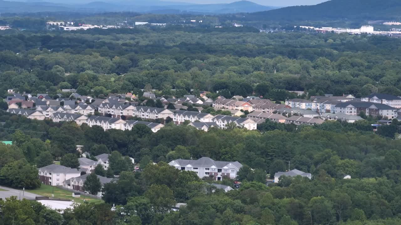 Row of two-story houses and townhouse in modern style. Suburb neighborhood of Americans town between green trees on mist summer morning.Aerial rising wide shot