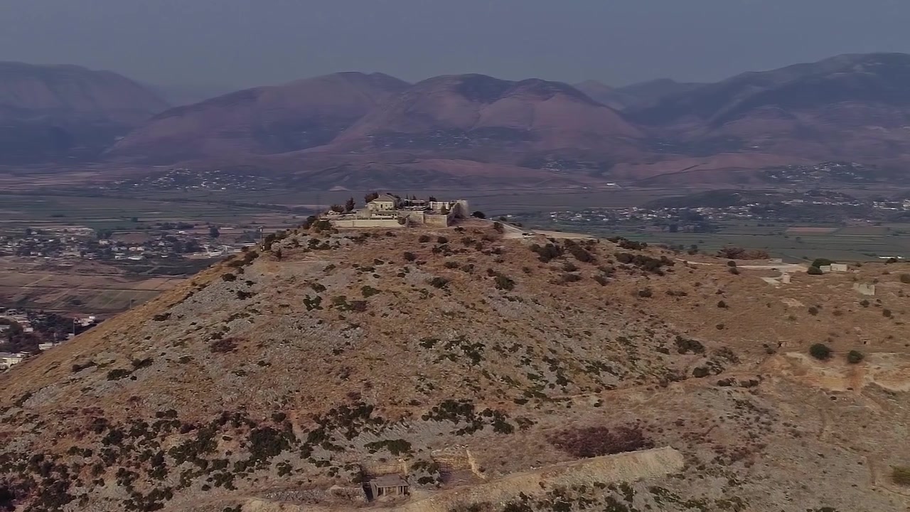 Vista di una collina con una struttura in cima in Albania in lontananza