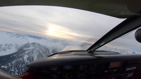 view from the cockpit of a plane flying around whistler, canada at sunset