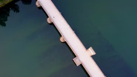 Top-down-aerial-of-famous-bridge-over-the-drina-river-in-Visegrad,-Bosnia