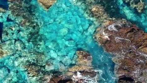 aerial drone footage of the natural pools of garachico caletón. blue ocean and the natural pools functioning as playas at tenerife. nice waves hit the rocks in the water.