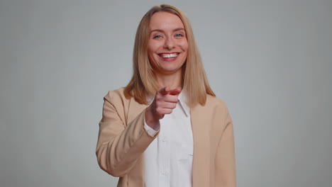 woman pointing to camera and looking with playful happy expression making choice showing direction