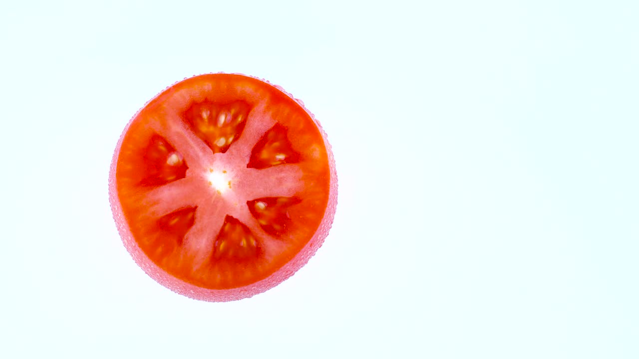 은 토마토의 단면의 위쪽 전망의 절반 프레임, 색 배경에 고립된 회전 테이블에서 회전.