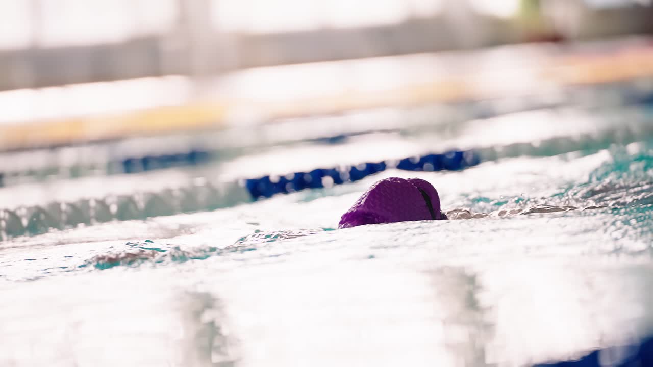 Zeitlupe-Nahaufnahme eines Schwimmers beim Kraulen im Pool