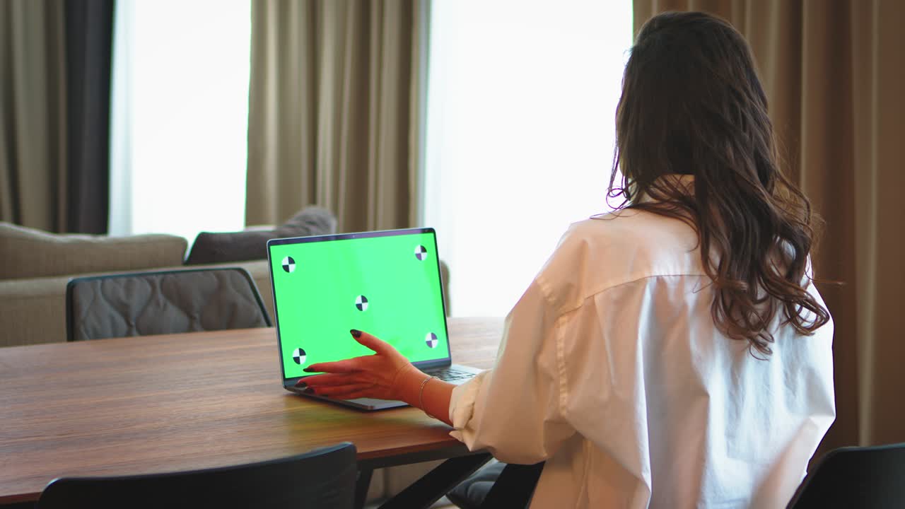 pantalla verde, llave de croma de la computadora portátil. trabajadora de la oficina en el hogar con videocall. marcadores de seguimiento