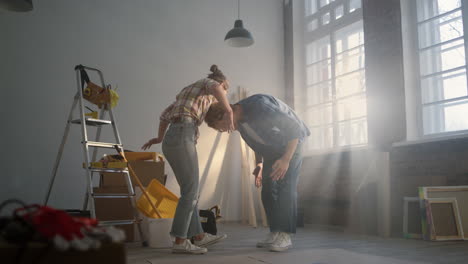 cheerful couple having fun indoors. joyful family dancing in new apartment..