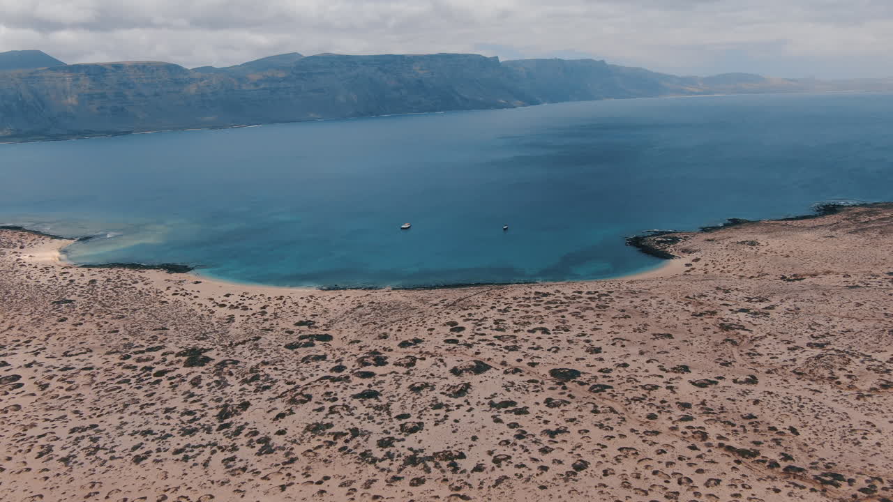Cinematic aerial shot of La Concha Beach and where you can see the large nearby mountains