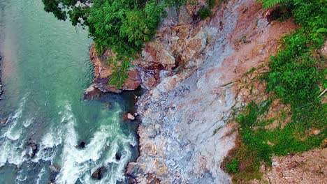 steep rocky cliff with a river flowing below