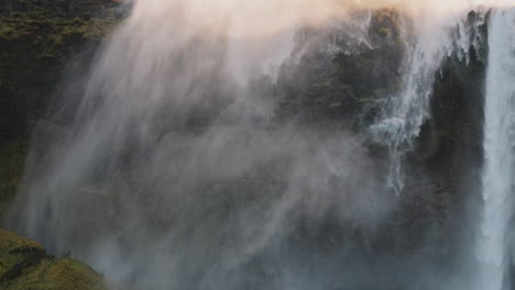 high wind creates dramatic waterfall cyclone in iceland, static shot, sunlight