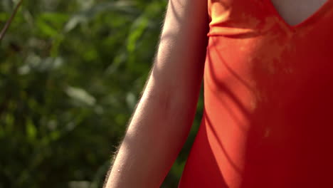 toma estática de una persona femenina con vestido rojo de verano, relajante al aire libre en la naturaleza, cámara lenta