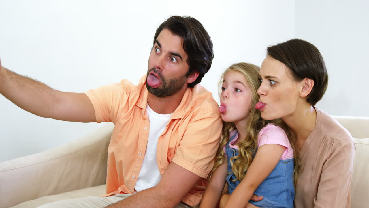 Familia adorable haciendo muecas y tomando una foto