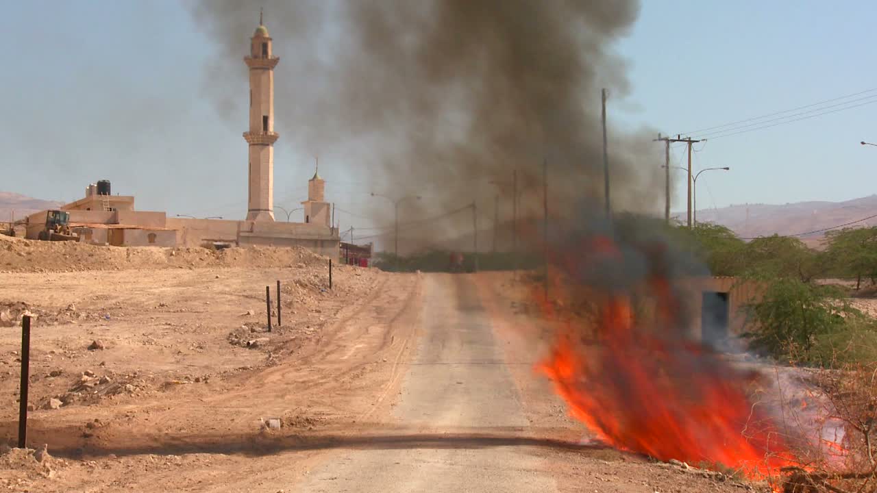 Un fuoco arde su una strada solitaria vicino a una moschea nei Territori Palestinesi 2.