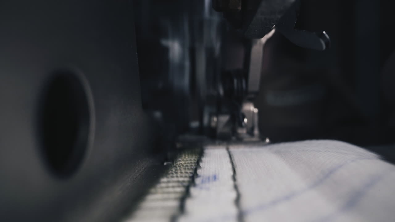 빨간색 매니큐어 를 한 여자 가 작업실 에서 보호 마스크 를 바느질 한다