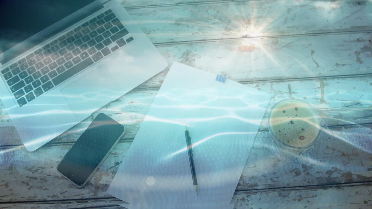 Office scene showing silver laptop, phone, paper with clip, pen, coffee mug under digital wave