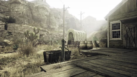 dusty settlement with wooden structures and a covered wagon at twilight