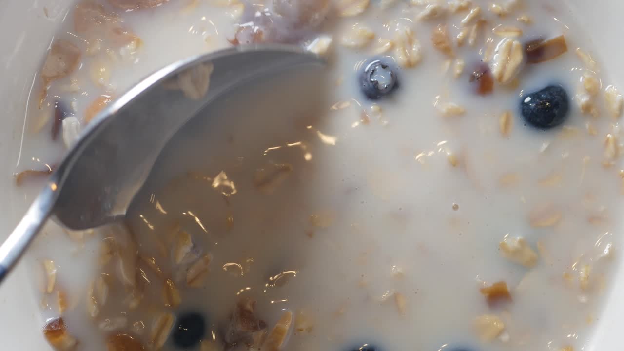 Primo piano di cereali con mirtilli e latte mescolati