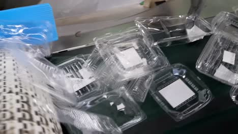 Used polypropylene box on conveyor belt in recycle factory. Close up shot. Industrial, equipment, production, and manufacturing concept.