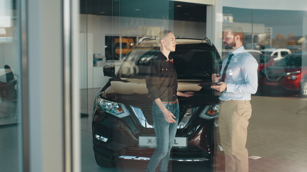 자동차 대리점 고객이 차량을 보고 있습니다.