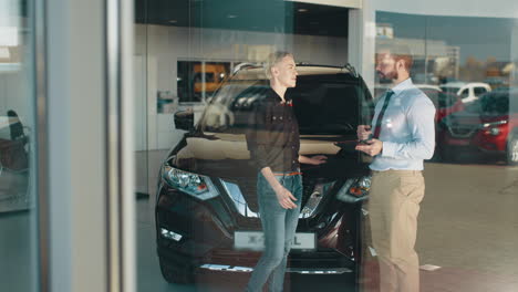 cliente de un concesionario de automóviles viendo un vehículo