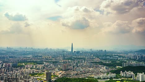 beams of sunlight break through moody clouds to illuminate the massive cityscape of seoul, south korea, with the iconic lotte world tower serving as the central focal point.