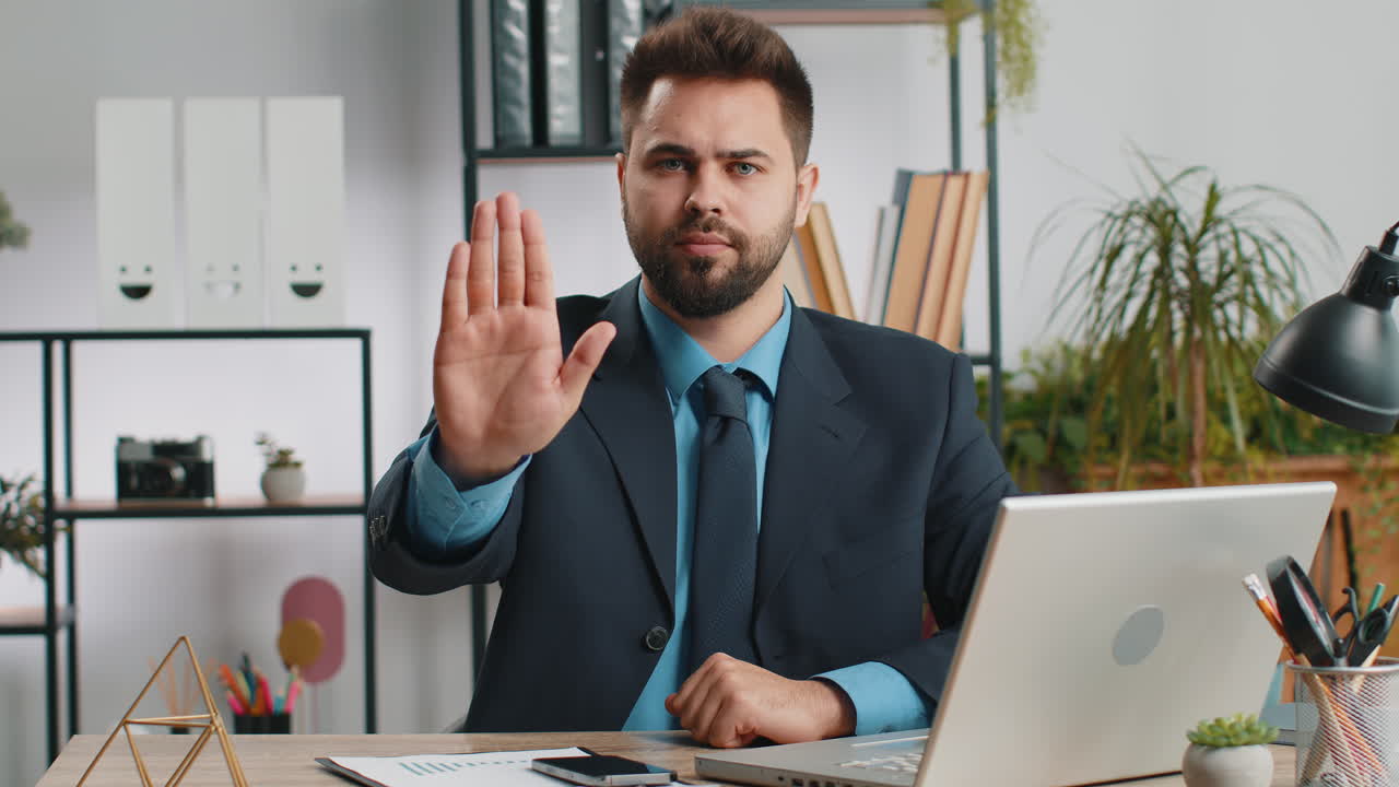 Businessman working on laptop showing stop gesture danger rejection warning crisis prohibition