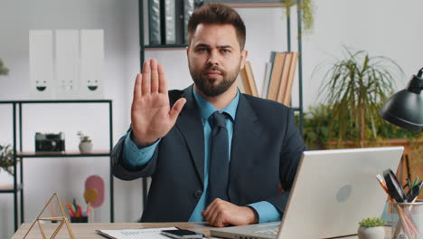 businessman working on laptop showing stop gesture danger rejection warning crisis prohibition