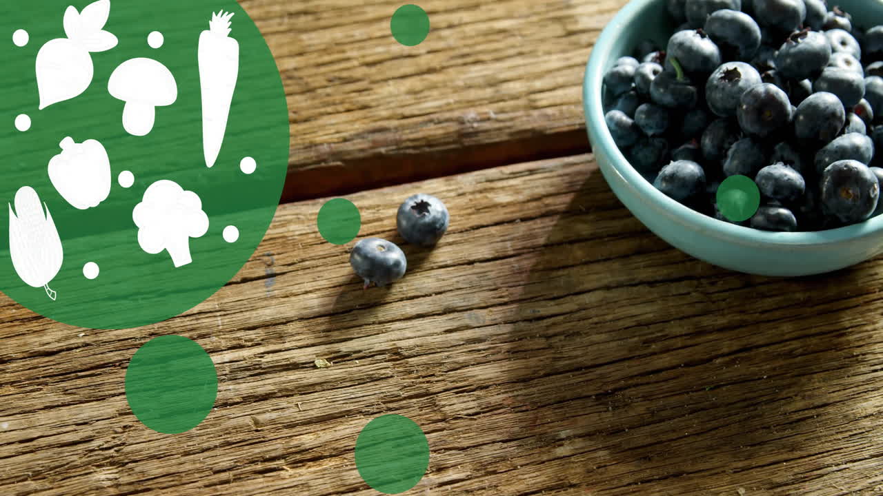 Animation of vegetable icons over blueberries in bowl on table