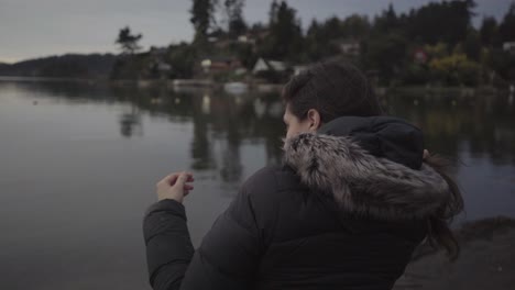 mujer sentada junto al lago