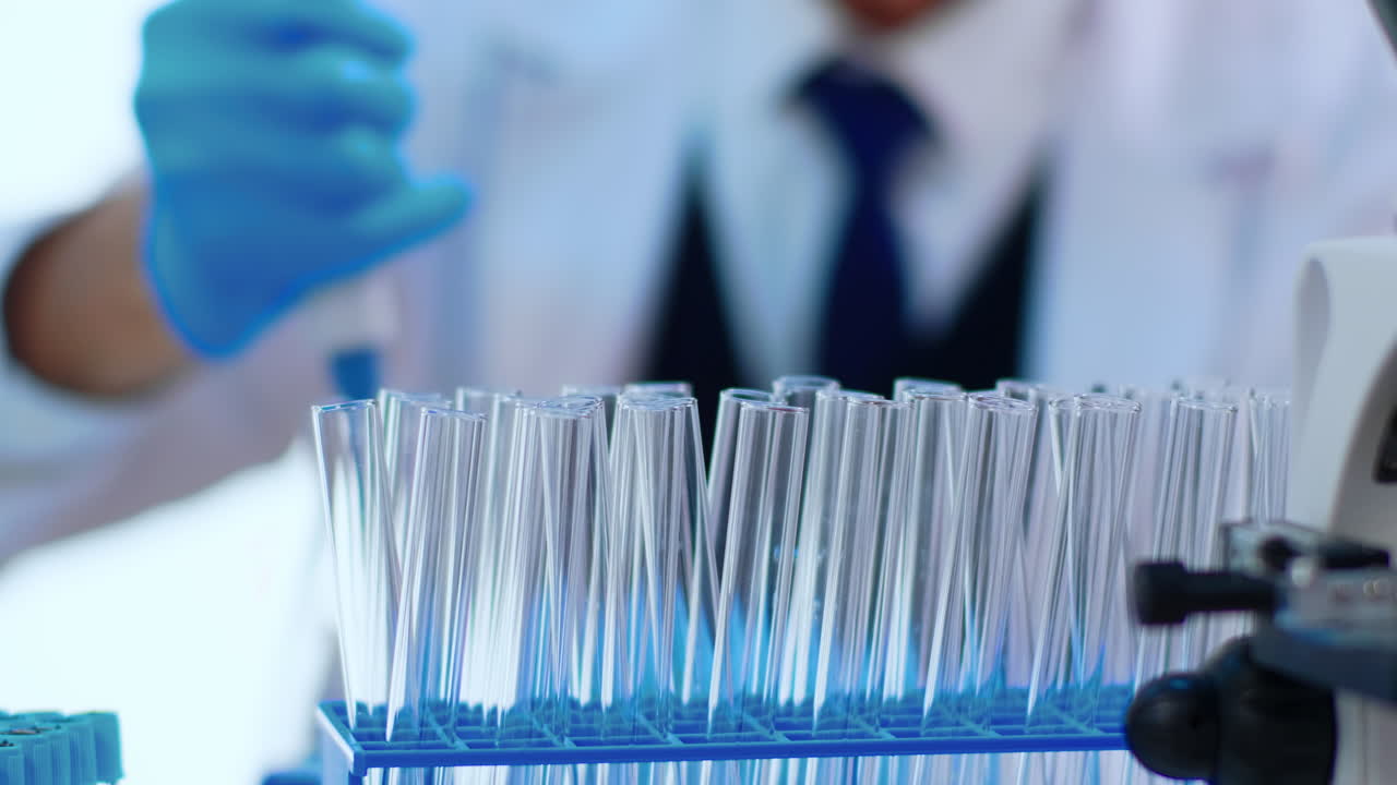 Close up of chemist filling test tube with liquid using pipette