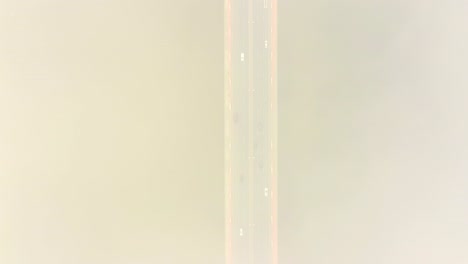 aerial drone view. bridge in the rays of a sunny morning. autumn haze in the air, cars are driving across the bridge. cloudy day