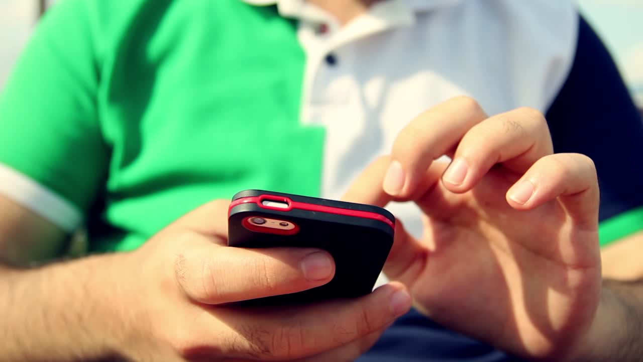 joven usando su teléfono inteligente en un café cerca de las manos 9