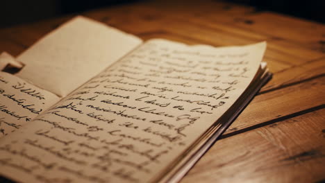 open vintage book with handwritten notes on wooden table