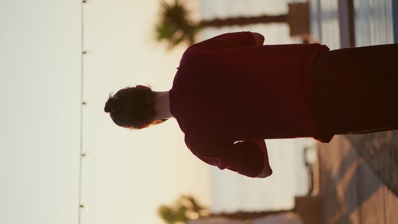 수직 비디오: 빨간 티셔츠를 입은 남자가 해변에서 명상을 위해 손을  ⁇ 고 있습니다. 마음과 몸의 휴식