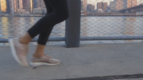 a woman running along the east river at sunrise in new york