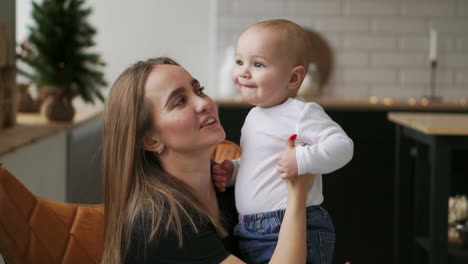 Joven-Madre-Sosteniendo-A-Su-Hijo-Recién-Nacido-A-Cámara-Lenta.-Familia-En-Casa,-Mamá-Y-Bebé,-Para-Navidad