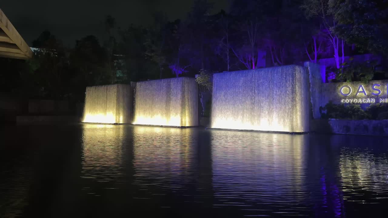 Water fountain with waterfalls in shopping mall at night