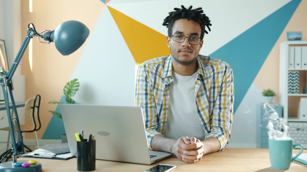 retrato cinematográfico de un apuesto hombre de negocios afroamericano en un escritorio en una habitación de oficina