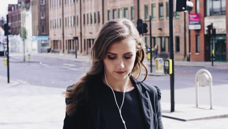 attractive business woman commuter using smartphone walking in city of london