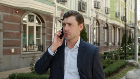 closeup businessman talking phone outdoor. male entrepreneur walking