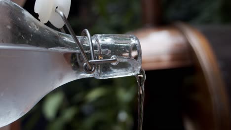 chef pouring cold water from a glass bottle