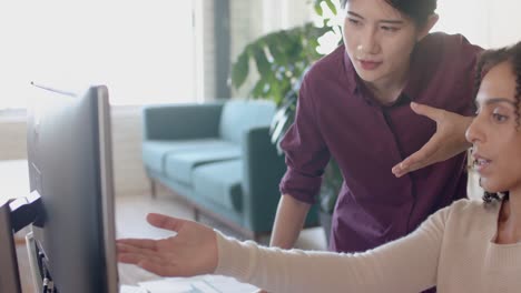 busy diverse casual businesswomen using computer and talking in office in slow motion